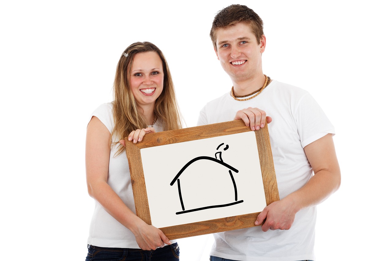 couple holding up picture of house
